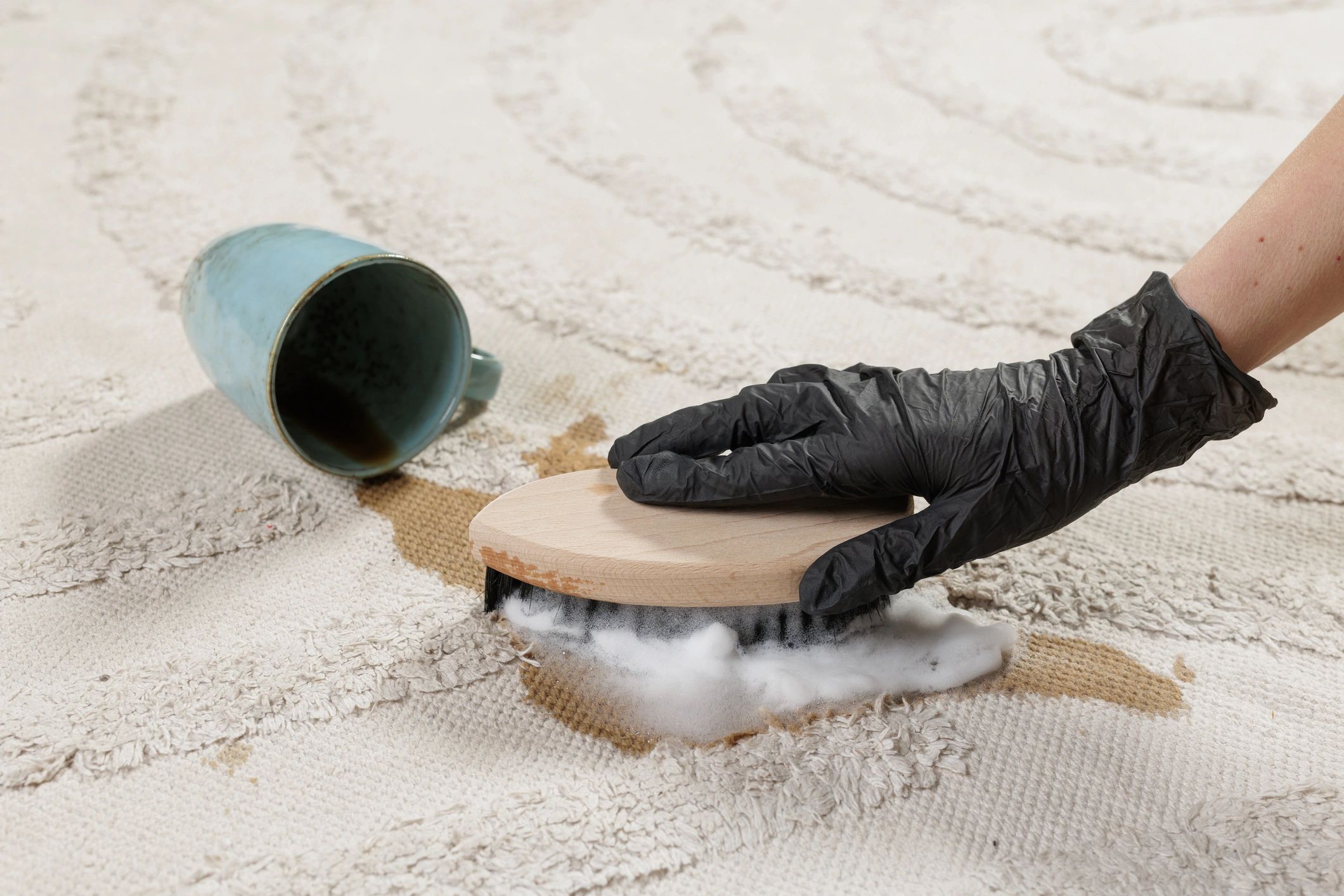 Professional stain treatment on a rug during cleaning